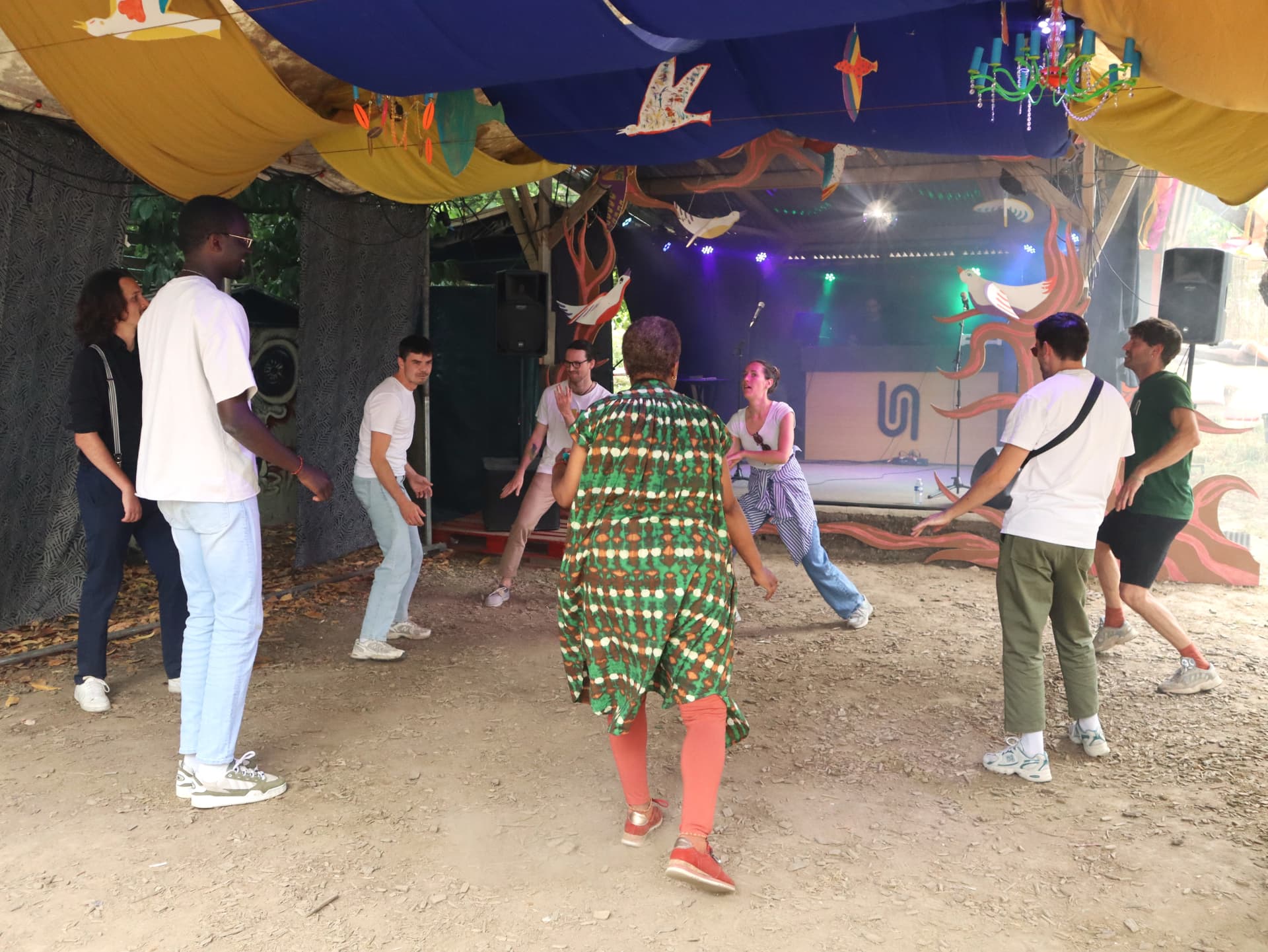 Participant·es en cercle, en mouvement sous un chapiteau, lors d’un atelier KADANSÉ !