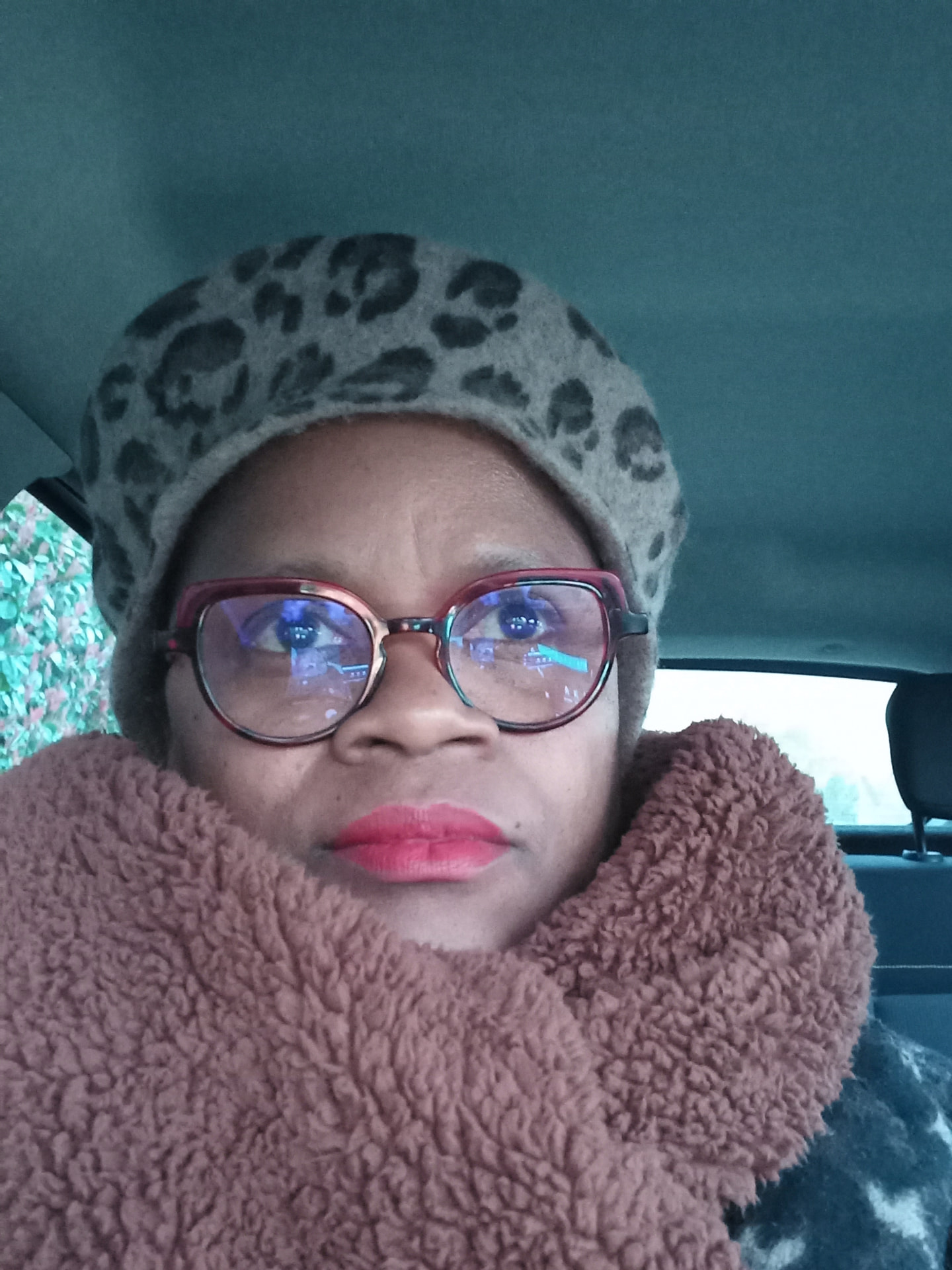 Autoportrait de MariCé avec lunettes, bonnet léopard et écharpe.