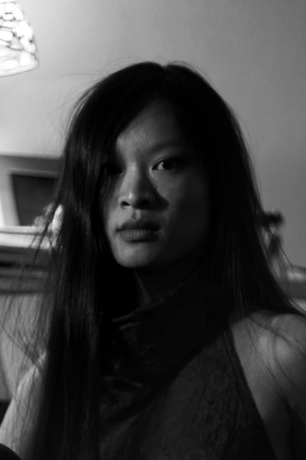 Portrait en noir et blanc d'Héléna Riols, regard vers l'objectif, longs cheveux noirs.